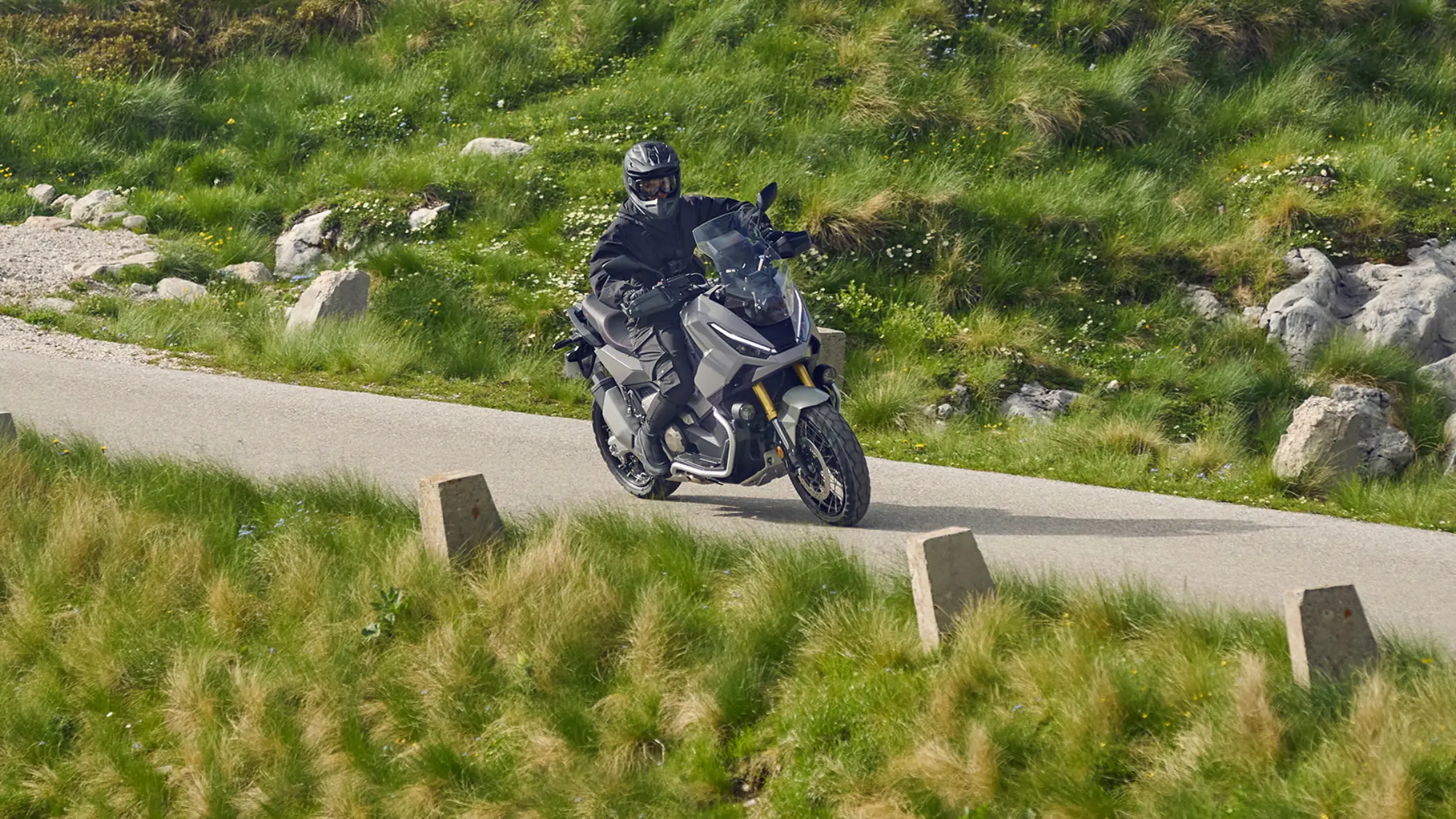 Motoros egy Honda X-ADV nyergében hegyvidéki helyszínen.